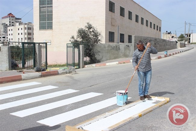 بلدية دورا ترسم خطوط المشاة أمام مدارس المدينة